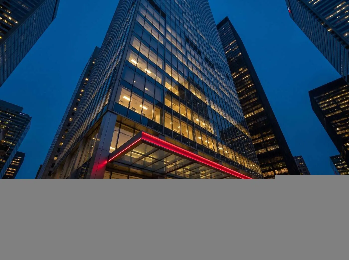 Glass bank tower in Toronto's financial district at blue hour with a crimson-lit lobby canopy